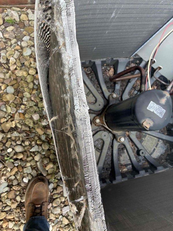 Completed spring maintenance on commercial HVAC unit. Discovered severely clogged outdoor evaporator coil with heavy accumulation of dirt, debris, and organic matter throughout fin structure. Damaged filter mesh noted and torn sections documented. Cleaned coil thoroughly to restore proper airflow and heat transfer efficiency. Inspected compressor unit, associated piping, and electrical connections for wear and proper operation. Replaced standard air filter with new Koch brand pleated filter. All equipment tested and operating within normal parameters following maintenance procedures.