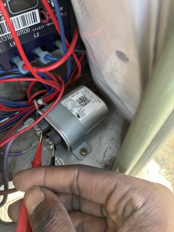 Completed spring preventive maintenance on commercial HVAC unit. Performed electrical diagnostics including capacitor testing with multimeter, verifying voltage readings at 694V and inspecting wire connections and terminals. All components operating within normal parameters upon completion of scheduled maintenance inspection.