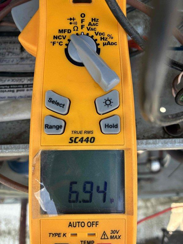 Completed spring preventive maintenance on commercial HVAC unit. Performed electrical diagnostics including capacitor testing with multimeter, verifying voltage readings at 694V and inspecting wire connections and terminals. All components operating within normal parameters upon completion of scheduled maintenance inspection.