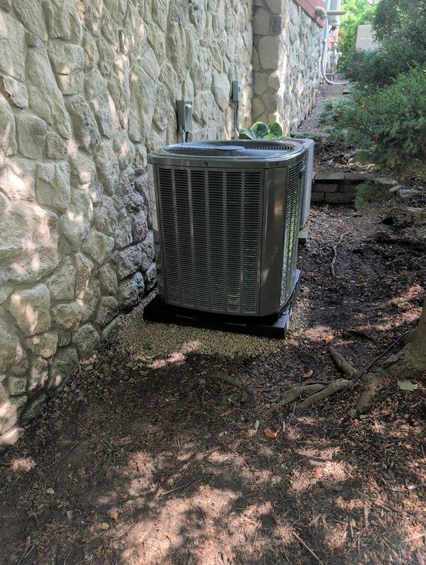 Completed AC retrofit installation including outdoor condenser unit and indoor evaporator coil. Positioned new condenser unit on exterior pad adjacent to stone wall with proper clearances for airflow and service access. Installed matching evaporator coil to work in conjunction with existing furnace system. Ran refrigerant lines between outdoor and indoor components, evacuated system, and charged to manufacturer specifications. Connected electrical service with appropriate disconnect box mounted on exterior wall. Verified all connections, tested system operation, and confirmed proper cooling performance across all parameters.