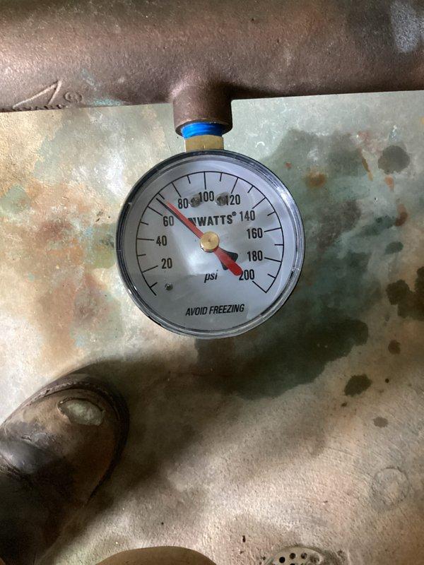 Performed pressure inspection of residential well water system. Examined pressure tank, associated plumbing connections, and pressure gauge which indicated system was functioning within normal operating parameters. Documented system configuration including stainless steel pressure tank, copper piping network, valves, and fittings for maintenance records.