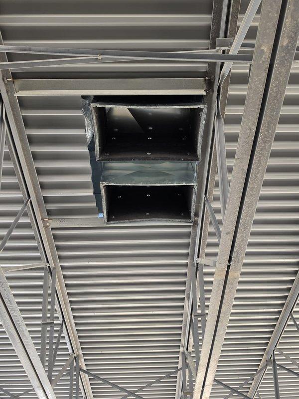 Conducted site visit to assess roof curb locations for new HVAC equipment installation on commercial construction project. Documented existing corrugated metal roof deck structure, support framework, and prepared roof openings with metal curb assemblies, confirming proper placement and structural support for future rooftop unit installations.