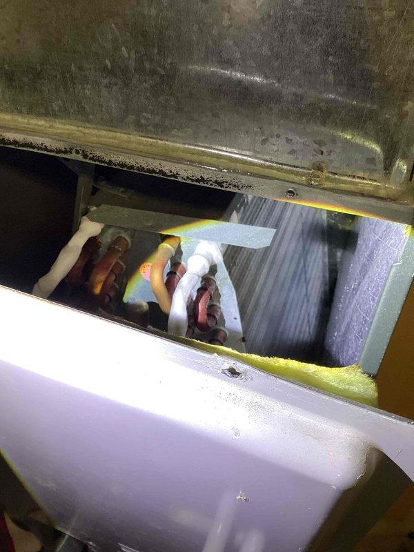 Responded to no cooling complaint at commercial office building. Accessed rooftop condenser unit and removed protective grille to inspect internal components. Found condenser coils heavily soiled with debris accumulation restricting airflow. Cleaned condenser coils, inspected refrigerant lines showing normal oxidation, and verified fan motor operation. Accessed interior mechanical cabinet and inspected refrigerant piping connections, ductwork, and associated components for leaks or damage. All connections secure with no refrigerant leaks detected. Reassembled equipment, restored power, and confirmed unit operating properly with adequate cooling to occupied space.