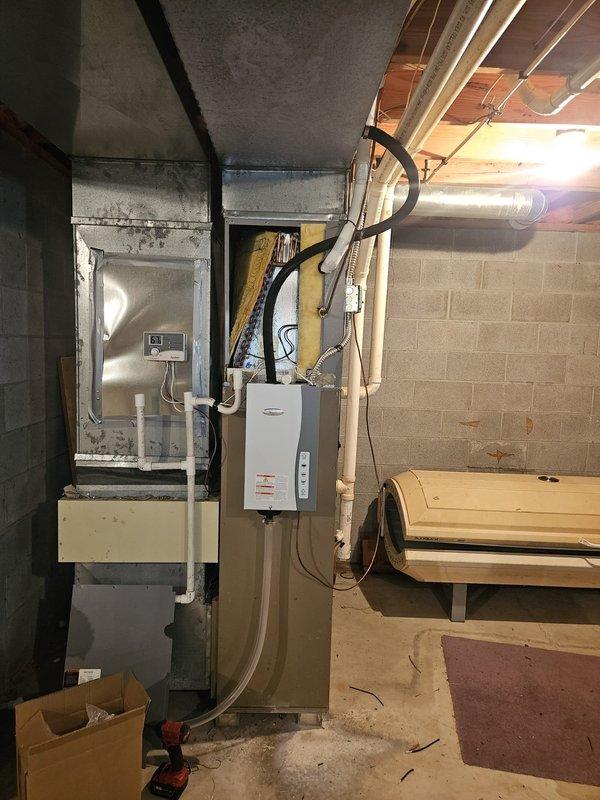 Responded to service call for 15-year-old air conditioning system not cooling effectively throughout residence. Upon arrival, performed comprehensive system inspection of indoor air handler and evaporator coil assembly located in basement utility area. Accessed internal components by opening upper plenum to examine evaporator coil condition and airflow restrictions. Evaluated thermostat operation, refrigerant line connections, condensate drainage system, and ductwork integrity. Documented equipment condition and system configuration with photographs for service records. System assessed and customer advised of findings and recommended next steps for restoring proper cooling performance.