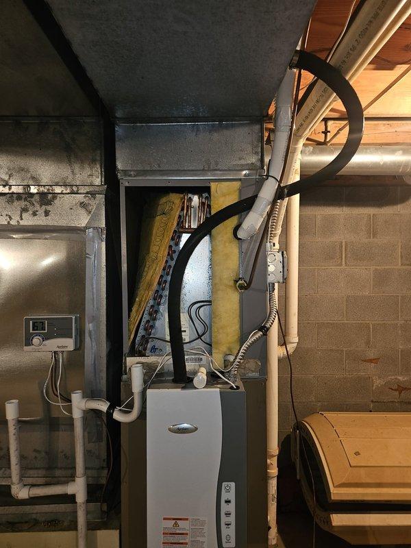 Responded to service call for 15-year-old air conditioning system not cooling effectively throughout residence. Upon arrival, performed comprehensive system inspection of indoor air handler and evaporator coil assembly located in basement utility area. Accessed internal components by opening upper plenum to examine evaporator coil condition and airflow restrictions. Evaluated thermostat operation, refrigerant line connections, condensate drainage system, and ductwork integrity. Documented equipment condition and system configuration with photographs for service records. System assessed and customer advised of findings and recommended next steps for restoring proper cooling performance.