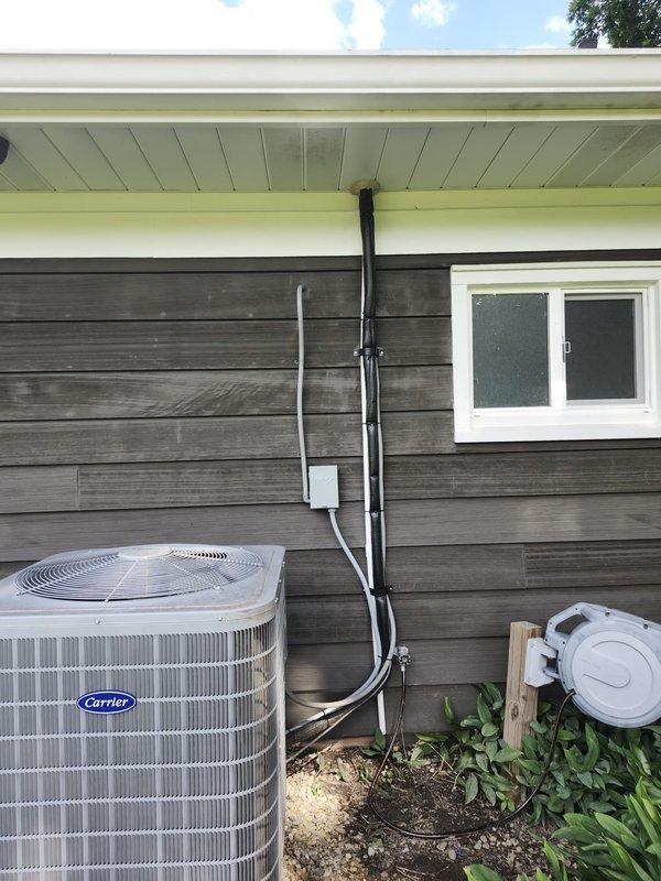 Responded to service call for air conditioning system leaking water. Upon inspection, identified condensate drain line issue at exterior unit and verified proper drainage from evaporator coil in attic space. Cleared blockage in PVC condensate line, tested system operation, and confirmed leak was resolved with no further water discharge observed at outdoor condenser unit.