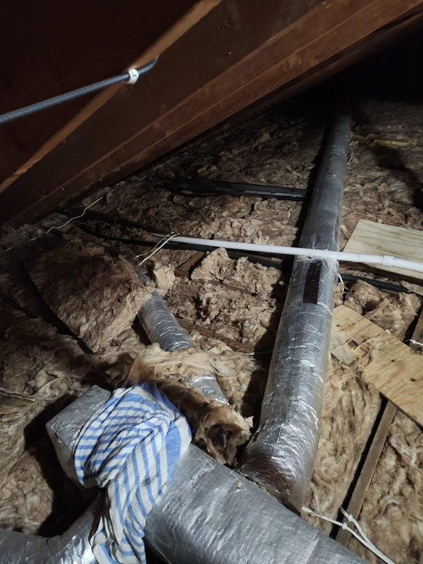 Responded to service call for air conditioning system leaking water. Upon inspection, identified condensate drain line issue at exterior unit and verified proper drainage from evaporator coil in attic space. Cleared blockage in PVC condensate line, tested system operation, and confirmed leak was resolved with no further water discharge observed at outdoor condenser unit.