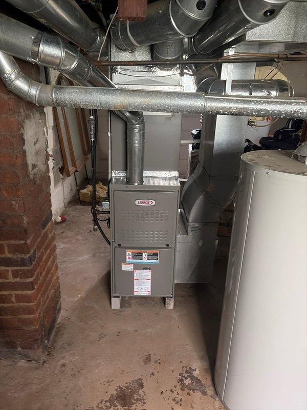 Completed furnace retrofit installation in basement mechanical room, replacing existing heating unit with new Lennox furnace system. Installation included proper ductwork connections with rigid and flexible metallic ducting, copper refrigerant line routing with insulation, and condensate drain trap with PVC drainage piping. All components properly secured and connected to existing HVAC infrastructure with system tested and verified operational.