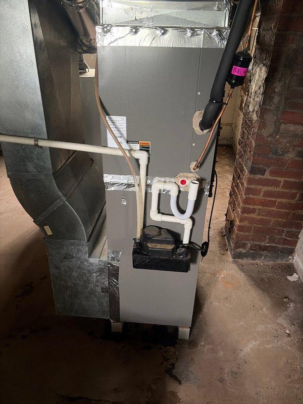 Completed furnace retrofit installation in basement mechanical room, replacing existing heating unit with new Lennox furnace system. Installation included proper ductwork connections with rigid and flexible metallic ducting, copper refrigerant line routing with insulation, and condensate drain trap with PVC drainage piping. All components properly secured and connected to existing HVAC infrastructure with system tested and verified operational.