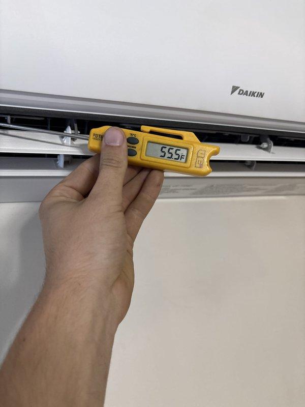 Replaced damaged outdoor mini split heat pump unit with new Daikin system. Completed refrigerant line pressure testing using digital manifold gauges, achieving leak-free results with 0.2% pressure drop over 5-minute test period at 423.3 psig. Verified proper system operation with supply air temperature reading of 55.5°F at indoor unit.