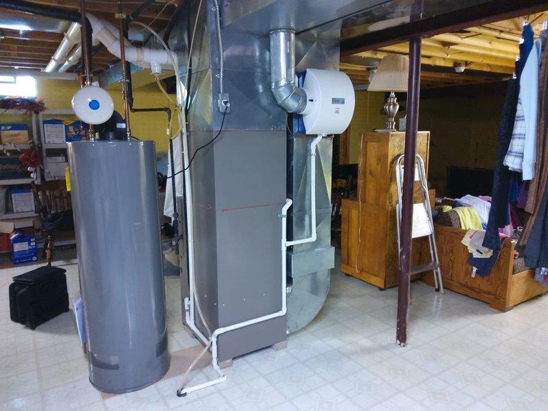 Completed comprehensive AC retrofit in basement utility area. Evaluated existing HVAC infrastructure including York furnace system with PVC venting and assessed compatibility with new air conditioning components. Documented pre-installation conditions of mechanical room layout, including water heater placement, ductwork configuration, and available clearances for equipment installation to ensure proper sizing and positioning of new AC system components.
