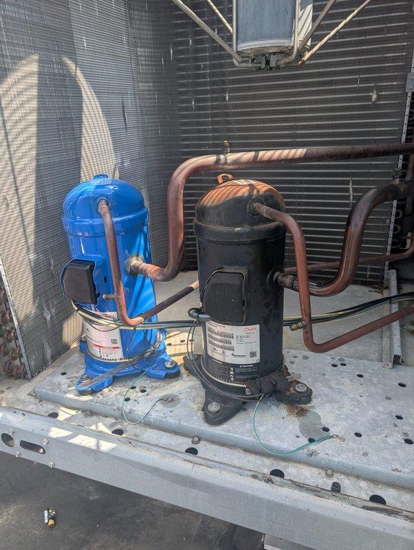 Replaced failed compressor on commercial HVAC unit. Ordered replacement compressor and necessary parts from supplier with 2-3 week lead time for delivery. Upon arrival of components, removed old blue compressor and installed new black unit, reconnected refrigerant lines and electrical connections, verified proper mounting and grounding, and replaced worn BX-70 Power King Cog belt on associated equipment. System tested and operational upon completion.