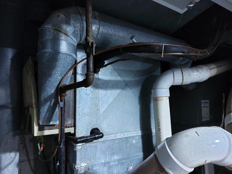 Completed comprehensive estimate for full HVAC system replacement in residential mechanical room. Assessed existing furnace unit, ductwork configuration, and condensate drainage system including PVC piping network with multiple connections and joints. Documented current equipment condition, spatial constraints in utility area, and recommended complete system upgrade to improve efficiency and reliability.