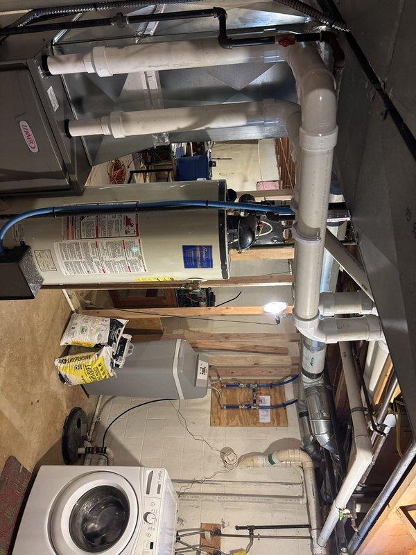 Completed furnace retrofit in basement mechanical room, installing new Lennox high-efficiency gas furnace with associated white PVC venting system routed vertically through ceiling. Integrated unit with existing ductwork infrastructure, including large-diameter supply plenum and 16x25 return air configuration. All electrical connections, condensate drainage, and combustion air venting installed per manufacturer specifications and local code requirements.