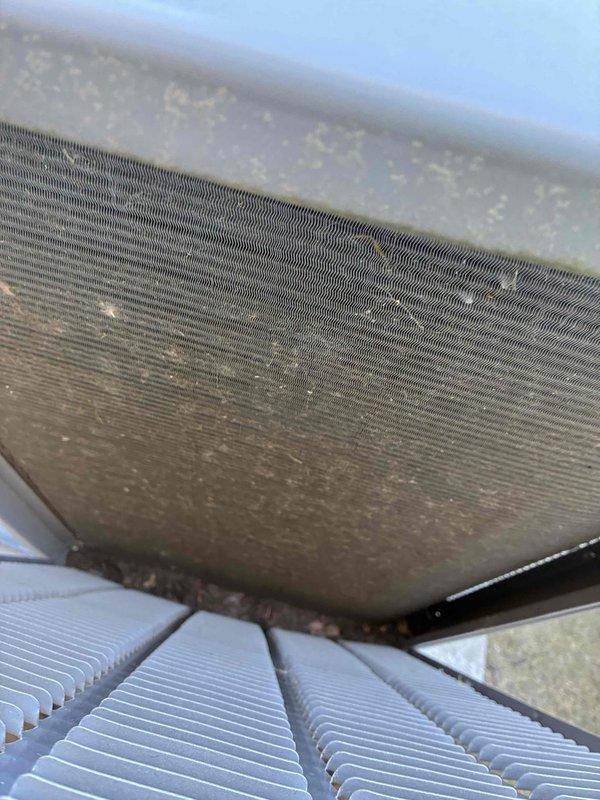 # HVAC Maintenance - Contract Visit - Commercial

Completed scheduled spring preventive maintenance on commercial HVAC unit. Upon inspection, discovered heavy accumulation of dust, dirt, and debris throughout heat exchanger coils and condenser fins, significantly restricting airflow and reducing system efficiency. The buildup was particularly concentrated in the upper coil sections, with substantial particulate matter lodged between the metallic fins. 

Performed thorough cleaning of all accessible coil surfaces to restore proper airflow channels and optimize heat transfer capability. Removed accumulated debris from fin structures and mounting components. Documented pre-maintenance conditions showing the extent of contamination and post-cleaning results. System inspected and confirmed operational following maintenance procedures. Unit returned to normal service with improved airflow and heat exchange performance.