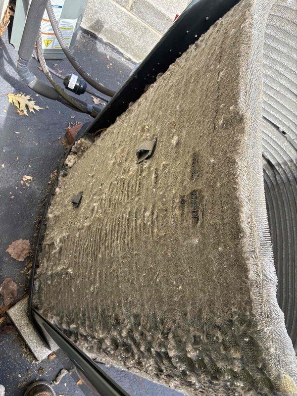 # Commercial A/C Service Call

Responded to service call for non-operational commercial air conditioning unit. Upon arrival, performed comprehensive system inspection and discovered severely compromised condenser coil with extensive dirt, dust, and debris accumulation throughout the aluminum fin assembly. The heavy contamination was restricting airflow and preventing proper heat exchange, resulting in system failure.

Documented pre-service condition showing thick grayish-brown buildup embedded throughout the finned surfaces, with particularly dense accumulation in multiple areas. The condenser coil exhibited signs of extended operation without routine maintenance, including bent fins and environmental debris lodged between fin spacing. This contamination was significantly reducing the unit's cooling capacity and efficiency.

Performed thorough condenser coil cleaning using appropriate chemical cleaners and pressure washing techniques to remove all accumulated dirt and debris from the 