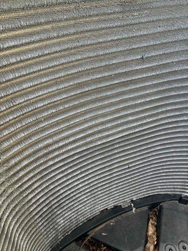 # Commercial A/C Service Call

Responded to service call for non-operational commercial air conditioning unit. Upon arrival, performed comprehensive system inspection and discovered severely compromised condenser coil with extensive dirt, dust, and debris accumulation throughout the aluminum fin assembly. The heavy contamination was restricting airflow and preventing proper heat exchange, resulting in system failure.

Documented pre-service condition showing thick grayish-brown buildup embedded throughout the finned surfaces, with particularly dense accumulation in multiple areas. The condenser coil exhibited signs of extended operation without routine maintenance, including bent fins and environmental debris lodged between fin spacing. This contamination was significantly reducing the unit's cooling capacity and efficiency.

Performed thorough condenser coil cleaning using appropriate chemical cleaners and pressure washing techniques to remove all accumulated dirt and debris from the 