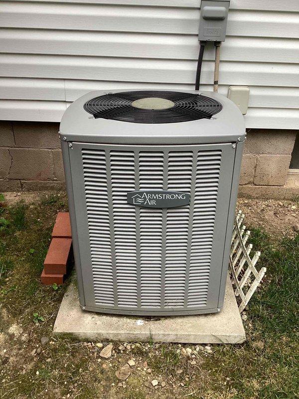 Completed routine maintenance on a 4-year-old Armstrong Air residential cooling system. Performed standard inspection of outdoor condensing unit, including evaluation of condenser coils which showed minor discoloration and potential algae buildup on aluminum fins. Verified fan assembly operation, checked electrical components including capacitor, and confirmed unit functionality. System operating within normal parameters following maintenance procedures.