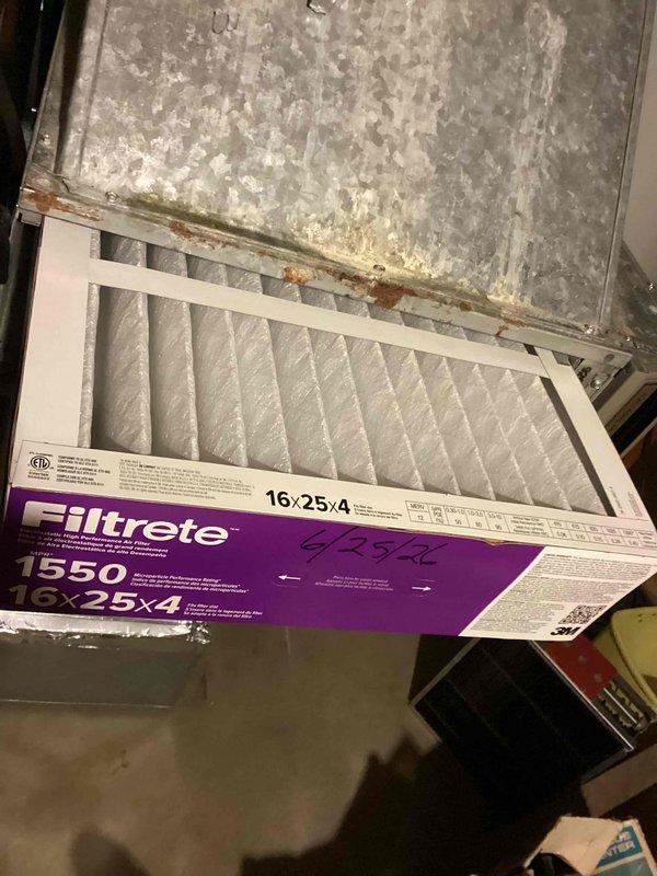 Completed spring maintenance on residential cooling system. Installed new Filtrete 1550 air filter (16x25x4) in HVAC system, noting significant deterioration and rust on metal filter housing that will require monitoring. Inspected outdoor Emerson condenser unit and observed excessive vegetation growth around base restricting airflow. Cleared grass and weeds from perimeter of unit to restore proper ventilation and prevent potential efficiency loss or compressor damage. Condenser housing showed weathering consistent with age but unit operational. Recommended ongoing vegetation management around outdoor unit and future assessment of corroded filter compartment housing for potential replacement to prevent air quality issues and maintain system integrity.