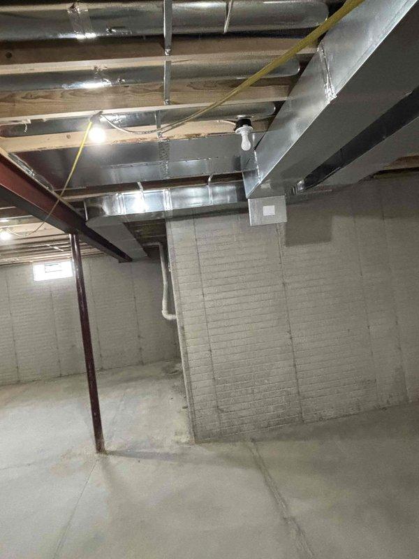 Completed new construction HVAC ductwork installation in unfinished basement mechanical space. Installed and secured multiple runs of rectangular sheet metal supply and return ductwork throughout the space using metal strapping and hangers attached to floor joists and structural supports. All ductwork properly sized, sealed, and suspended to building code specifications to serve the conditioned spaces above.