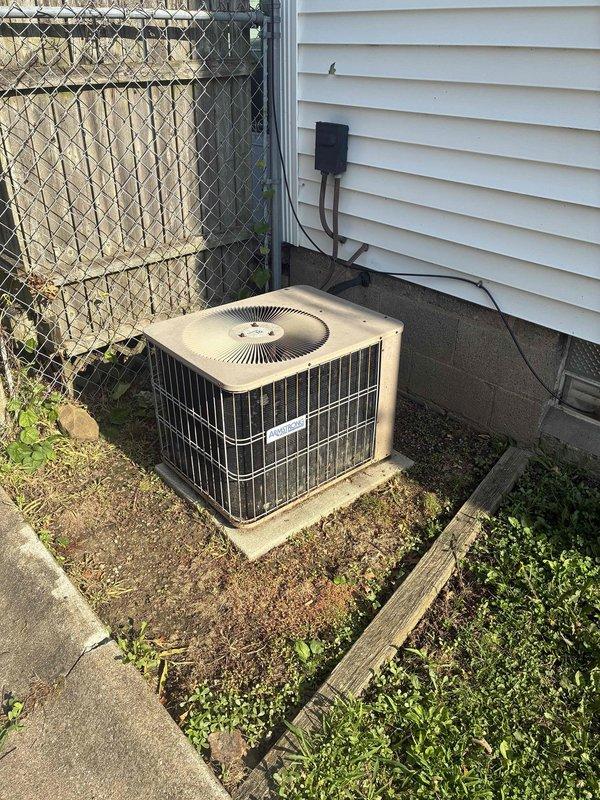 Completed spring maintenance on residential cooling system. Performed comprehensive inspection of outdoor condenser unit, verified electrical connections at disconnect box, and recorded system readings with meter displaying 1251 (likely voltage or pressure measurement). Unit operating within normal parameters with no immediate service needs identified.