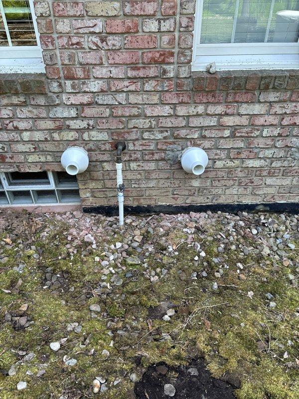 Completed final installation of HVAC condensate drainage system for new construction project. Installed and secured white PVC condensate drain lines through exterior brick foundation wall with proper pitch and mounting brackets. Verified all drain line connections, tested system operation, and documented completed installation with photographic records of exterior penetrations and drainage assembly.