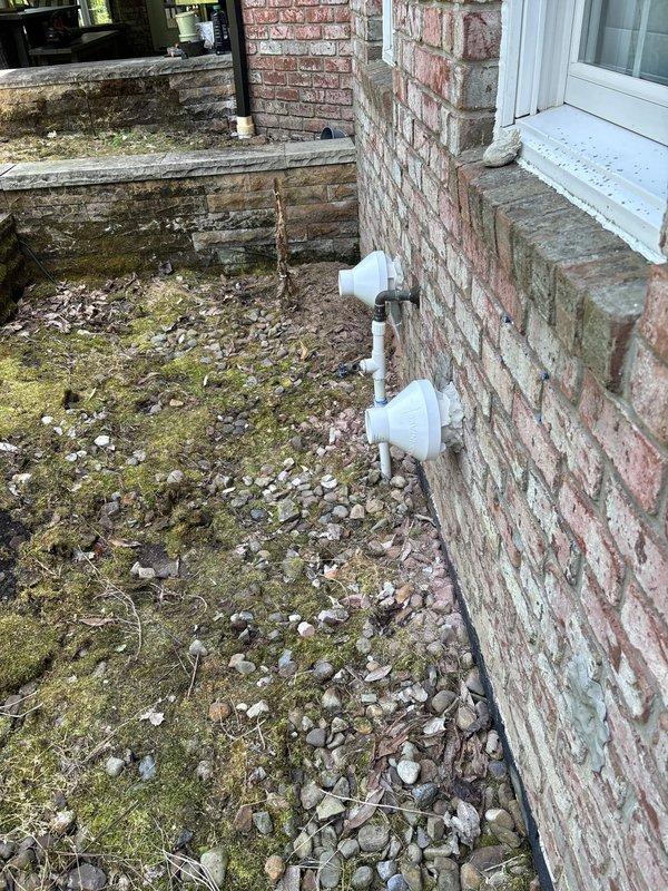 Completed final installation of HVAC condensate drainage system for new construction project. Installed and secured white PVC condensate drain lines through exterior brick foundation wall with proper pitch and mounting brackets. Verified all drain line connections, tested system operation, and documented completed installation with photographic records of exterior penetrations and drainage assembly.
