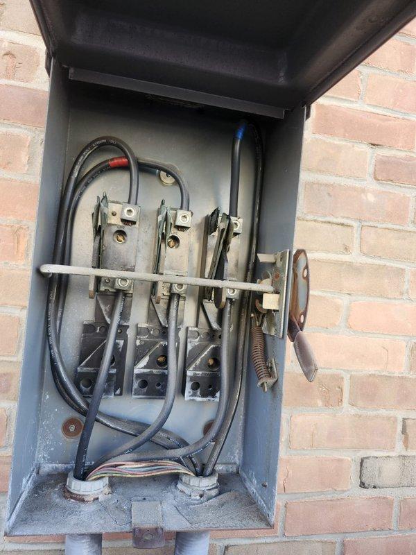 Responded to no cooling complaint on commercial rooftop unit. Upon arrival, inspected RTU and associated electrical components including rooftop disconnect switch. Documented equipment condition showing significant age and weathering on unit housing with visible rust and corrosion on exterior panels. Electrical disconnect examined with cover open, revealing three-blade fuse assembly and associated wiring connections in serviceable condition despite surface oxidation consistent with outdoor exposure. Customer advised to contact when technician en route for service completion.