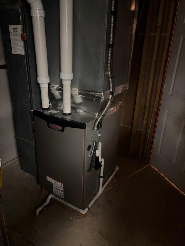 Completed full furnace and evaporator coil replacement in residential basement location. Removed existing equipment and installed new high-efficiency furnace unit with proper venting system utilizing white PVC intake and exhaust pipes secured with metal strapping. Connected flexible metal ductwork to furnace outlet and verified all connections were properly sealed. Installation includes proper clearances, secure mounting on concrete pad, and compliance with manufacturer specifications and local code requirements.