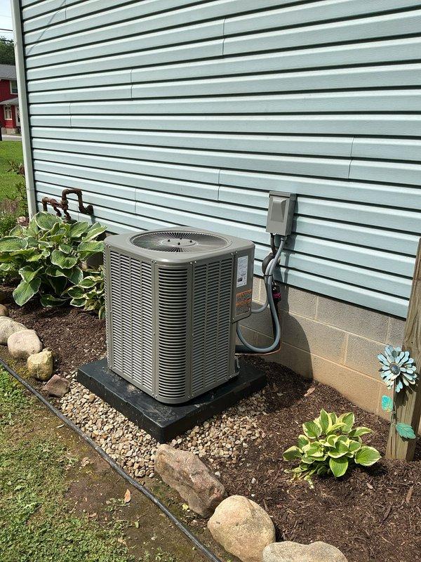 Completed full HVAC system retrofit including furnace and air conditioning condenser installation. New furnace unit was installed in basement utility area with proper ductwork connection to existing supply plenum, and outdoor condensing unit was positioned on protective pad with gravel base and professional landscaping integration. All electrical connections, disconnect box, conduit runs, gas lines, and refrigerant lines were properly installed and tested to manufacturer specifications, with system commissioned and verified operational.