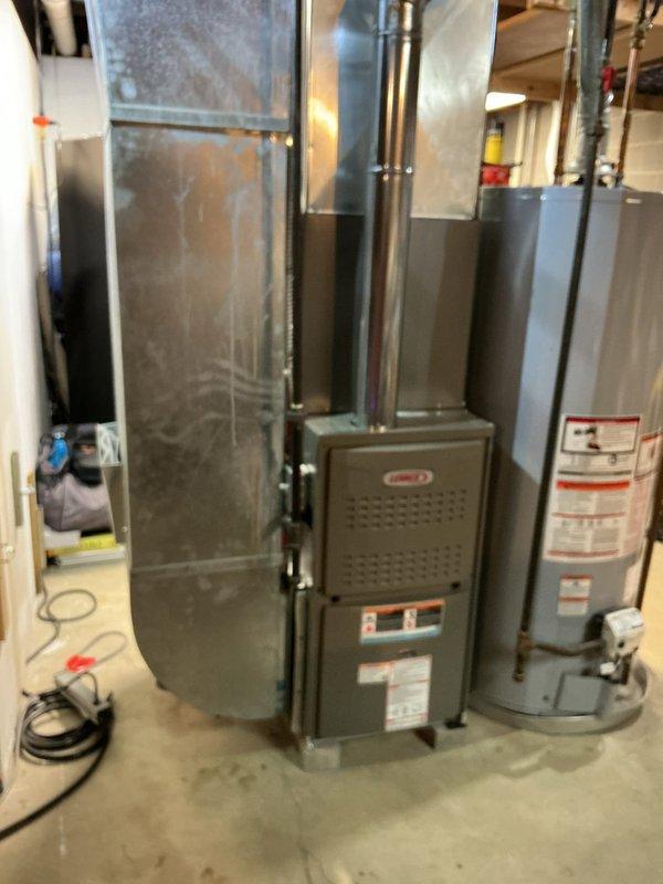 Completed full HVAC system retrofit including furnace and air conditioning condenser installation. New furnace unit was installed in basement utility area with proper ductwork connection to existing supply plenum, and outdoor condensing unit was positioned on protective pad with gravel base and professional landscaping integration. All electrical connections, disconnect box, conduit runs, gas lines, and refrigerant lines were properly installed and tested to manufacturer specifications, with system commissioned and verified operational.