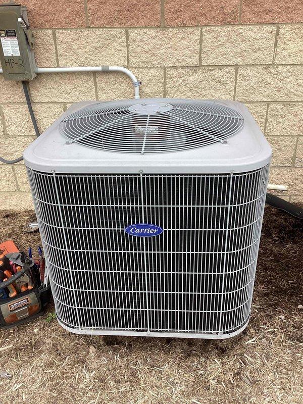Responded to no cooling complaint on commercial heat pump system. Inspected Carrier air handler in attic space and outdoor condensing unit, verified all electrical connections, refrigerant lines, and ductwork connections. System evaluated and photographed for documentation purposes.