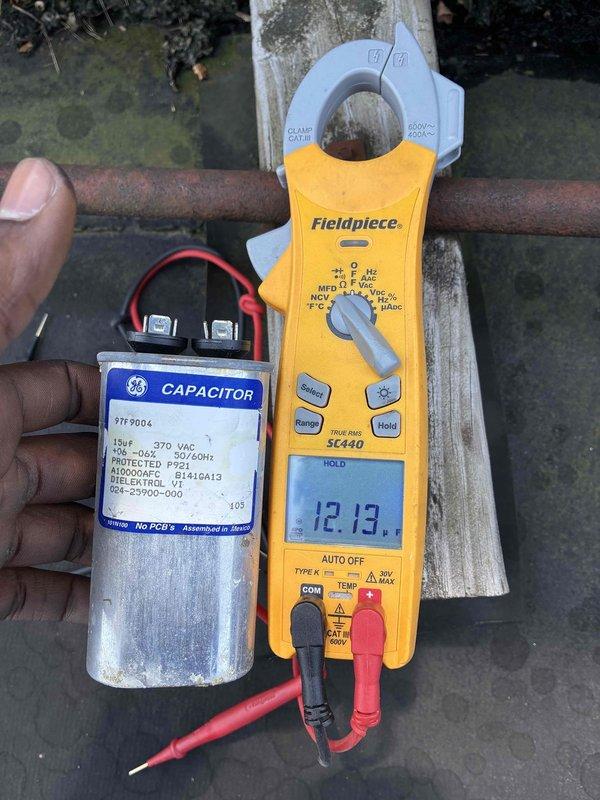 # Commercial A/C System Restoration

Responded to no-cooling call at commercial salon facility with reported high humidity levels causing moisture accumulation on furniture. Upon arrival, found system completely inoperative. Performed diagnostic testing on electrical components and identified failed capacitor as root cause of system failure. Measured electrical values using clamp meter to confirm capacitor degradation and verify proper amperage draw requirements for compressor operation.

Removed defective capacitor showing signs of age, corrosion, and electrical failure at terminal connections. Installed new GE replacement capacitor with appropriate microfarad and voltage ratings per manufacturer specifications. Reconnected all electrical leads to proper terminals, ensuring secure connections. Cycled system through complete startup sequence and verified normal operation. Confirmed compressor engaging properly and unit cooling effectively. System restored to full operational status, re