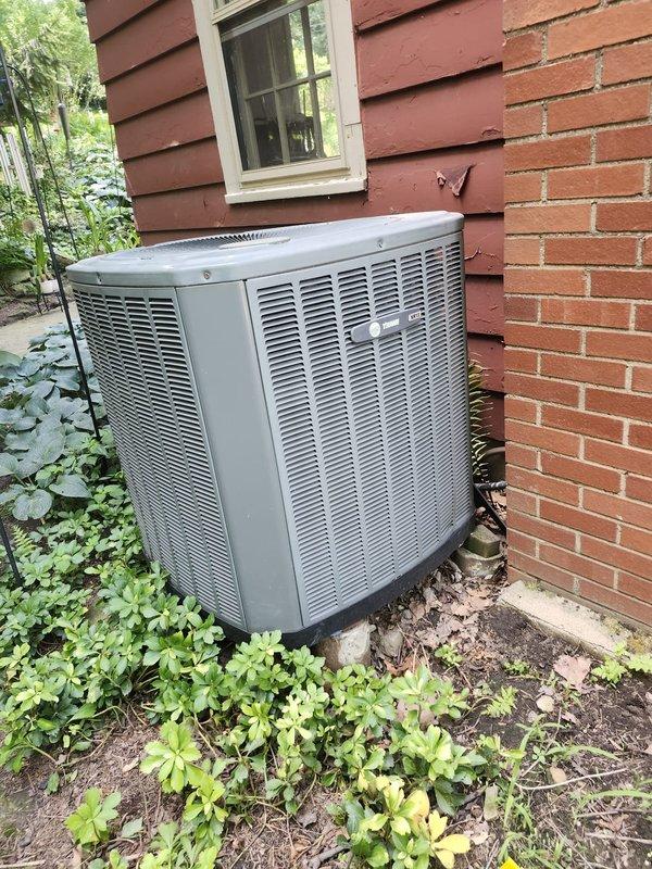 Completed full HVAC system retrofit installation including new furnace and air conditioning condenser unit. Positioned outdoor AC unit against exterior brick and wood siding with proper clearances, installed refrigerant line set, established electrical disconnect, and mounted unit on stable pad. System installed per manufacturer specifications with all components operational and ready for use pending completion of financing documentation.