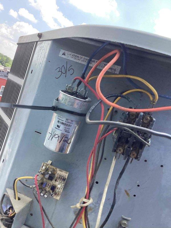 Responded to service call for non-operational rooftop air conditioning unit. Inspected Frigidaire commercial condenser and electrical panel, documenting capacitor dated 7/9/20 and all electrical connections including contactors, relays, and control board. Diagnosed system failure, performed necessary repairs to restore cooling operation to affected unit.