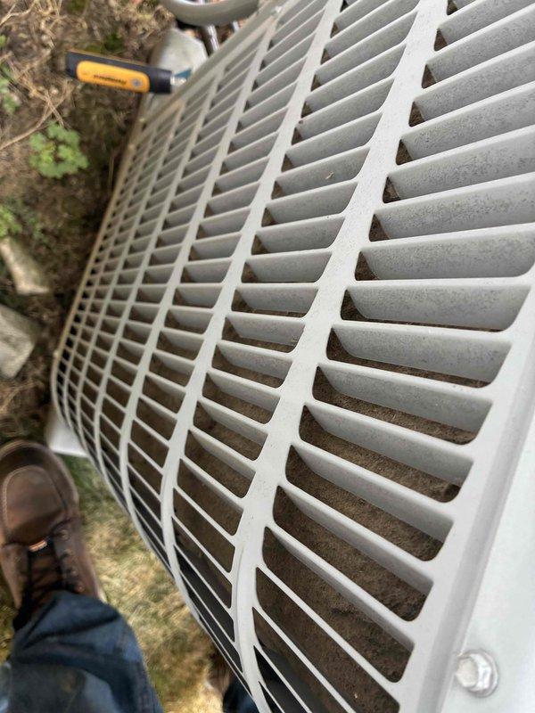 Responded to service call for air conditioning unit with reported leaking in bottom drain pan. Upon arrival, performed visual inspection of outdoor condensing unit. Examined electrical components including capacitor and associated wiring connections, noting normal wear and dirt accumulation consistent with outdoor exposure. Inspected condenser coil fins for debris buildup and blockage. Checked drain pan area for signs of water accumulation and potential condensate drainage issues. Documented unit condition with photographs showing interior electrical components and exterior housing. All wiring connections appeared secure with no signs of electrical failure or immediate safety concerns.