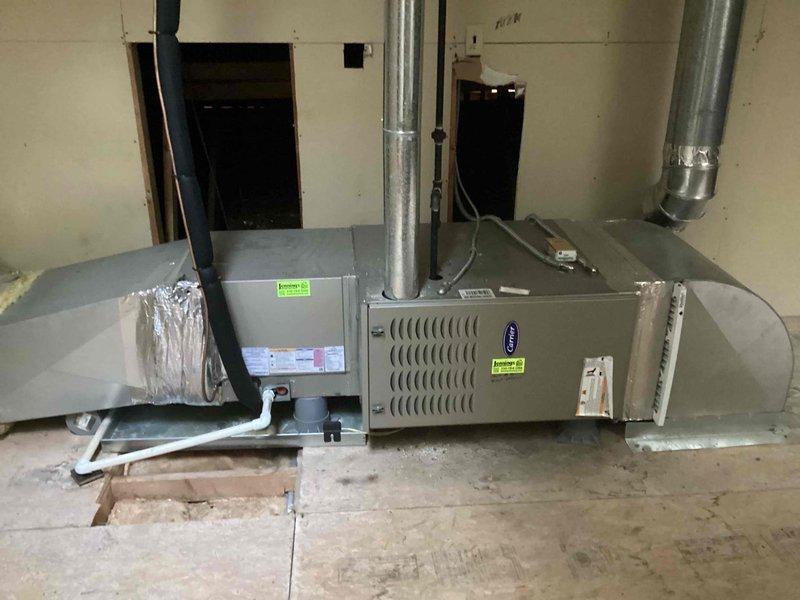 Completed scheduled commercial cooling maintenance visit. Inspected exterior Carrier condenser unit, noting normal weathering and operational condition of protective grille and components. Verified indoor horizontal furnace system, ductwork connections, and condensate drainage lines for proper operation and secure installation. All equipment functioning within normal parameters.