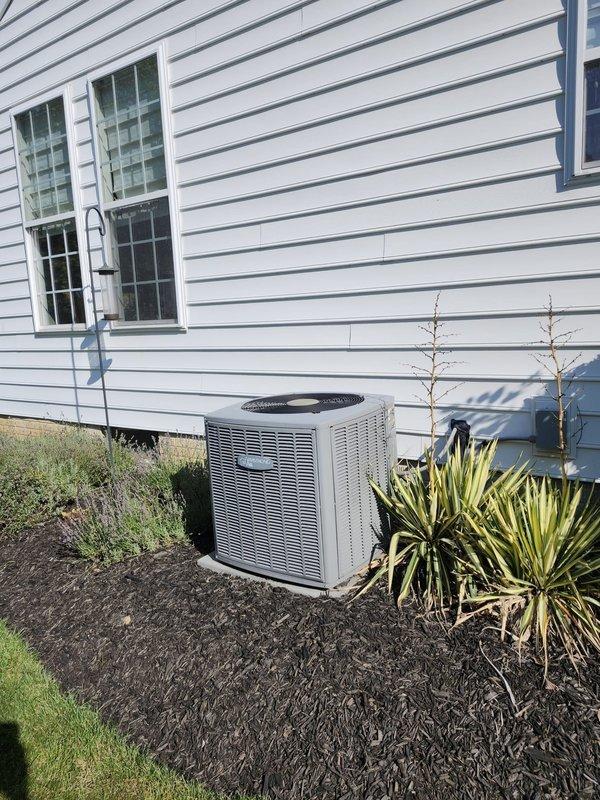 # AC Retrofit Installation

Successfully completed a full air conditioning system retrofit at a residential property. Installed a new outdoor condensing unit on a prepared mulch bed alongside the home's exterior, positioned for optimal airflow and accessibility. The beige-colored condenser was properly leveled and secured, with electrical conduit routed along the exterior siding to meet code requirements.

Inside the mechanical room, installed a new evaporator coil integrated with the existing HVAC system. Completed all refrigerant line connections using insulated copper piping, ensuring proper brazing and leak-free joints. Installed new PVC condensate drain lines with appropriate pitch and fittings to ensure proper drainage. Added a safety shutoff valve to the condensate system for overflow protection.

Connected electrical components including disconnect switches and verified proper voltage supply to the new equipment. Performed vacuum and pressure testing on the refrigerant lines, t