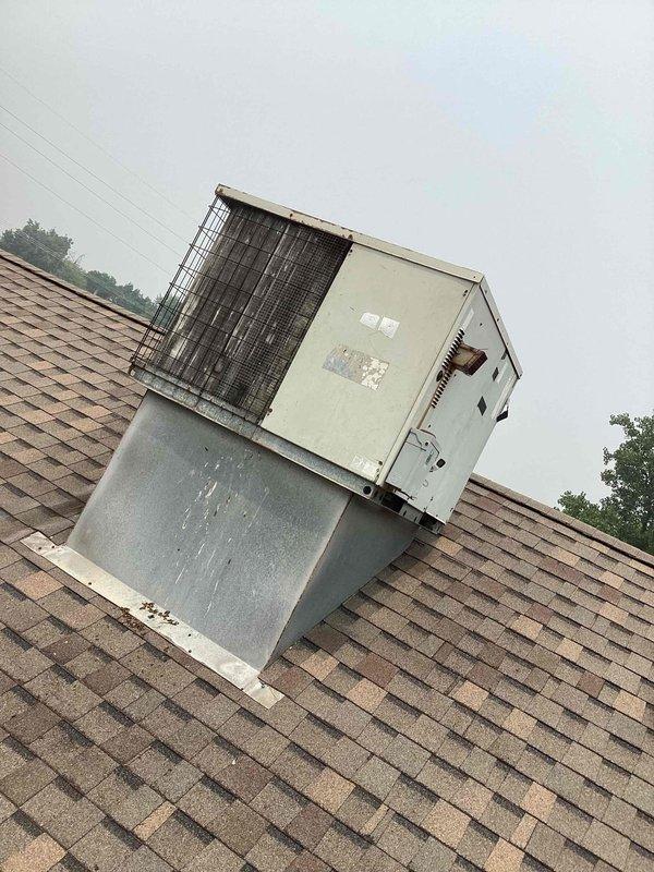 Responded to service call for non-operational commercial rooftop A/C unit. Upon arrival, found unit severely dislodged from curb mount at approximately 45-degree angle, likely due to storm damage or structural failure. Assessed electrical connections and refrigerant lines for damage, documented equipment displacement with photographs. Unit requires professional rigging equipment to safely reposition and secure to mounting curb, along with complete electrical and refrigerant system integrity testing before restoration to service.