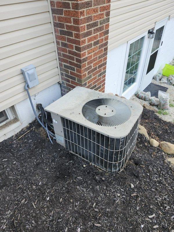 Completed full HVAC system retrofit including new furnace installation in basement utility area and outdoor air conditioning condenser unit placement on exterior of residence. The furnace was positioned on concrete floor with proper ductwork connections to existing plenum system, while the AC condenser was installed on prepared mulch bed against exterior wall near French door entry point. All refrigerant lines, electrical connections, and ductwork transitions were secured and tested to ensure proper system operation and efficiency.