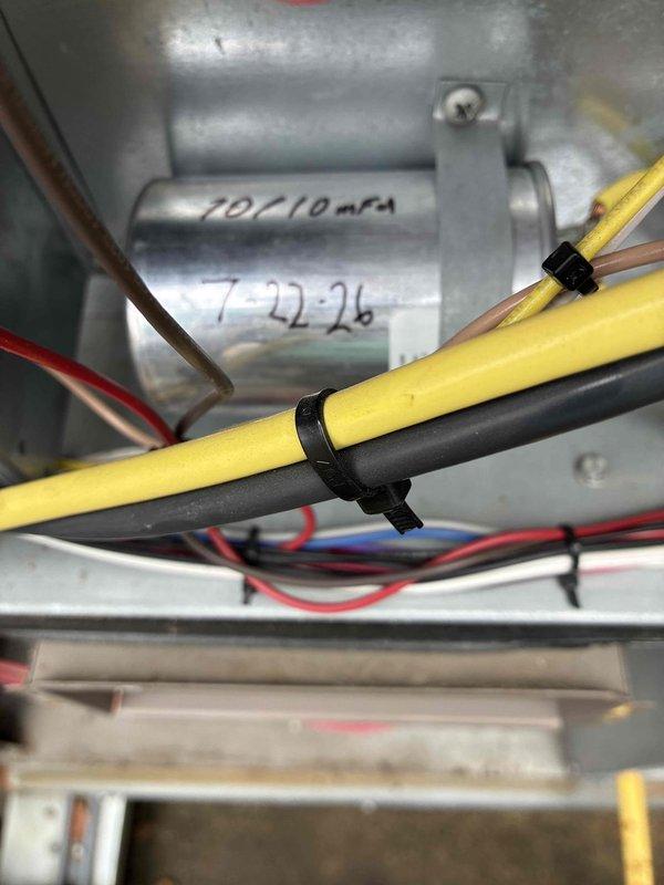 Responded to no cooling call for commercial HVAC system serving main hall area. Upon arrival, found Honeywell Home thermostat displaying "System: Wait - Waiting for update" error message with unit set to 65°F but showing actual temperature of 72°F with 61% humidity. Investigated system controls and internal components, inspecting wiring connections and electrical circuits within the air handler unit. Verified proper wire terminations and connections for yellow, black, brown, and red control wires secured with cable ties. Cleared system error, reset thermostat communication protocol, and restored normal cooling operation. System tested and verified functioning properly with thermostat responding to temperature setpoint adjustments.