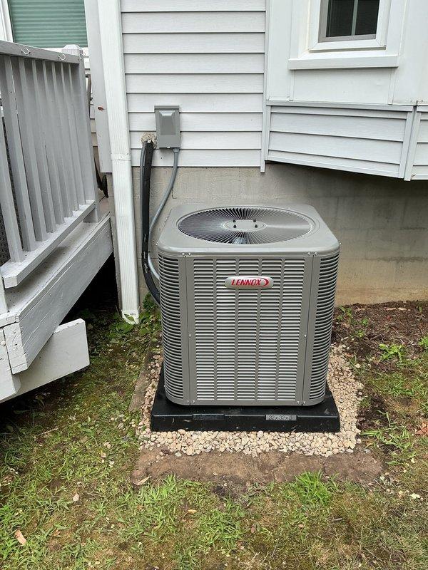 Completed AC retrofit installation at residential property. Installed new Lennox outdoor condensing unit on platform pad with gravel base against exterior wall, including electrical disconnect box and conduit connections. Interior installation included new evaporator coil integrated with existing Lennox furnace system in basement mechanical room, with proper refrigerant line connections and ductwork modifications to main plenum. System tested and verified operational with all electrical connections secured and refrigerant charge confirmed to manufacturer specifications.