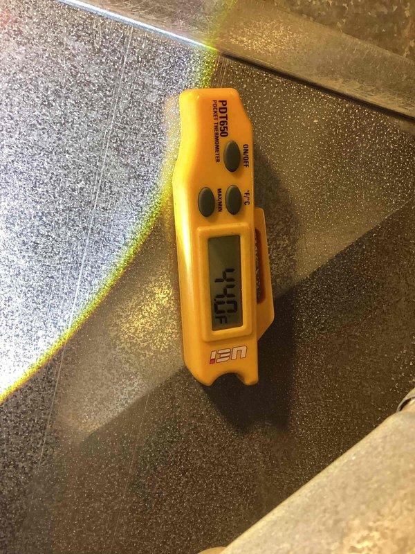 Performed routine preventive maintenance on commercial air conditioning condenser unit of unknown age. Conducted standard inspection of outdoor unit, verified operational status, and documented system temperatures using infrared thermometer, recording readings of -74.5°F at evaporator coil indicating proper refrigerant charge and cooling performance.
