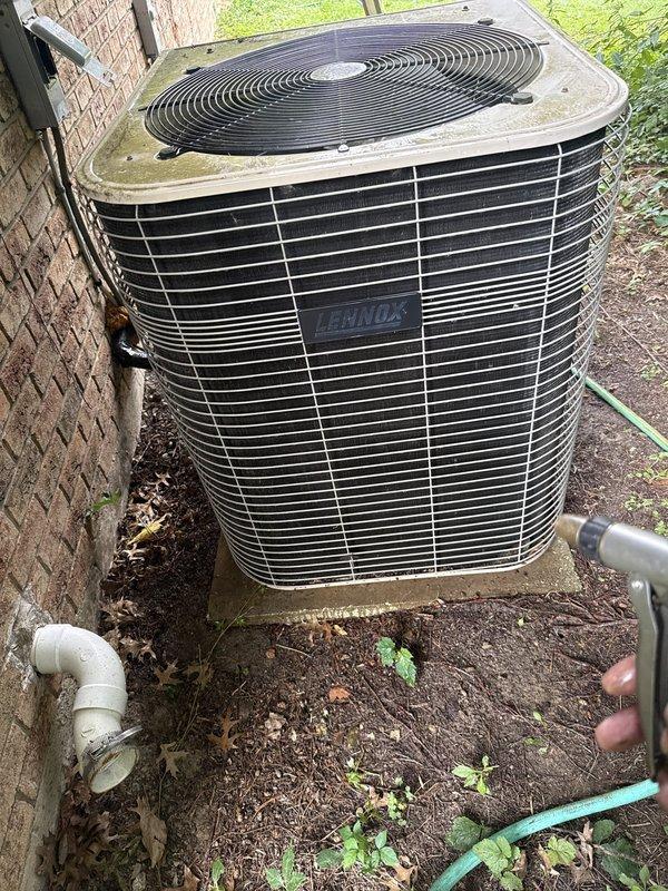 Performed cooling maintenance on 20-year-old Lennox condenser unit. Unit was accessible during 2-4 PM timeframe with advance notice. Observed significant algae and moss accumulation on cabinet surfaces and debris buildup around base of unit, which can restrict airflow and reduce system efficiency. Documented unit condition showing weathering consistent with age and environmental exposure in shaded installation location.