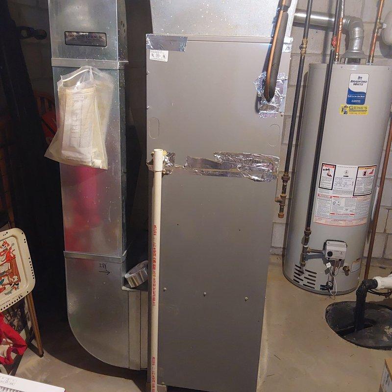 Completed comprehensive HVAC estimate for air conditioning retrofit in residential basement mechanical room. Assessed existing equipment configuration including current air handler, water heater, and associated ductwork systems. Documented condition of metal supply plenum showing significant dust accumulation and worn metallic tape at horizontal seam joint, indicating need for cleaning and resealing during replacement. Evaluated basement utility room layout and existing equipment placement to determine optimal configuration for new AC system installation. Photographed current HVAC components, ductwork transitions, and utility connections to develop accurate replacement specifications and identify any required modifications to existing infrastructure for proper retrofit integration.