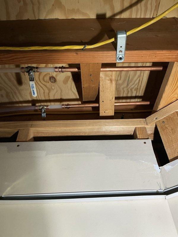 Responded to service call for two malfunctioning anti-freeze spigots located in separate areas accessible through drop ceiling. Inspected both frost-free hose bibs mounted on exterior wall with gray PVC supply lines and copper piping infrastructure visible in ceiling cavity. Verified proper operation of shutoff valves with blue handles on copper supply lines. Repaired and tested both anti-freeze spigots to ensure proper drainage function and freeze protection capability. Confirmed all connections secure and leak-free at both locations.