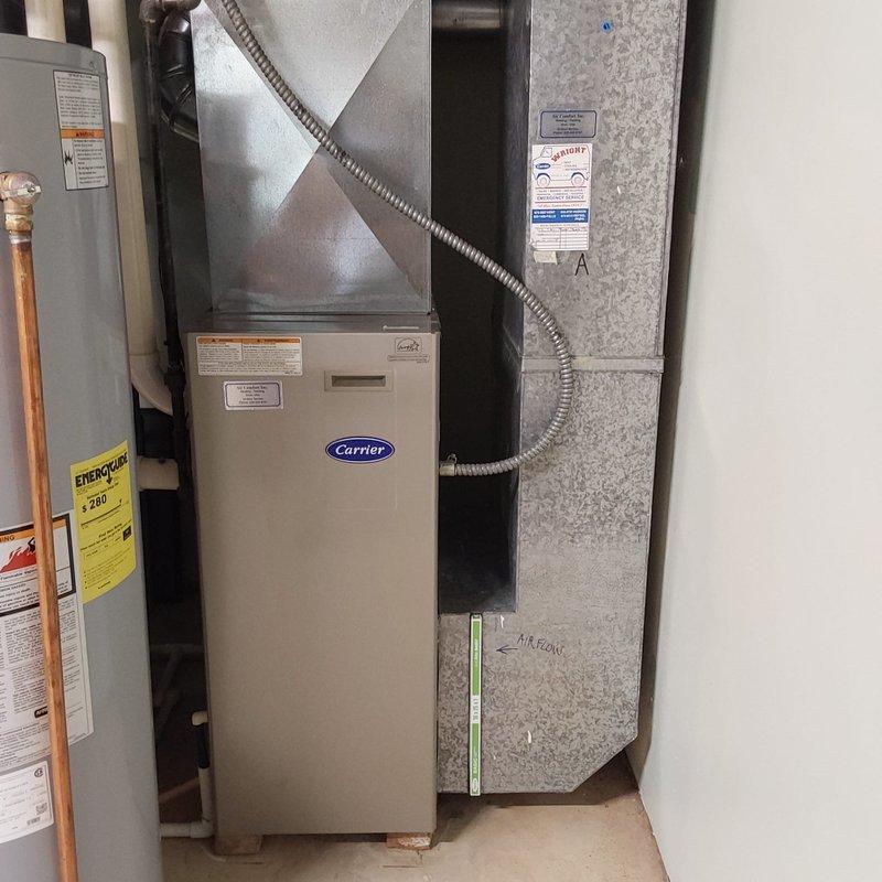 Completed furnace retrofit in residential basement mechanical room, installing new Carrier brand air handler unit to replace existing heating equipment. Installation included proper connection of ductwork with metallic plenum and flexible duct connectors, integration with existing water heater and plumbing systems, and verification of all electrical controls and thermostat functionality.