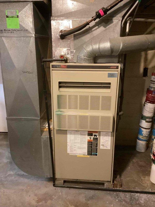 Responded to service call for commercial air conditioning system not maintaining setpoint temperature, with unit reading 72°F despite thermostat set to 70°F. Upon arrival, performed comprehensive system evaluation of split-system air conditioner including indoor furnace/air handler unit located in basement mechanical room and outdoor condensing unit. Conducted visual inspection of both components, checking for obvious signs of damage, deterioration, or system failures. Examined outdoor condenser unit positioned on concrete pad, verifying physical condition of cabinet, coil fins, fan assembly, and electrical connections at disconnect switches. Inspected indoor air handler and associated ductwork for proper installation and operational status. Evaluated system controls, electrical components, and refrigerant lines. Documented equipment conditions through photographic records showing Lennox furnace unit with connected gray metal ductwork and outdoor condenser with top-mounted fan assembly