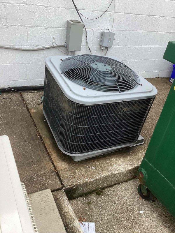 Responded to service call for commercial air conditioning system not maintaining setpoint temperature, with unit reading 72°F despite thermostat set to 70°F. Upon arrival, performed comprehensive system evaluation of split-system air conditioner including indoor furnace/air handler unit located in basement mechanical room and outdoor condensing unit. Conducted visual inspection of both components, checking for obvious signs of damage, deterioration, or system failures. Examined outdoor condenser unit positioned on concrete pad, verifying physical condition of cabinet, coil fins, fan assembly, and electrical connections at disconnect switches. Inspected indoor air handler and associated ductwork for proper installation and operational status. Evaluated system controls, electrical components, and refrigerant lines. Documented equipment conditions through photographic records showing Lennox furnace unit with connected gray metal ductwork and outdoor condenser with top-mounted fan assembly
