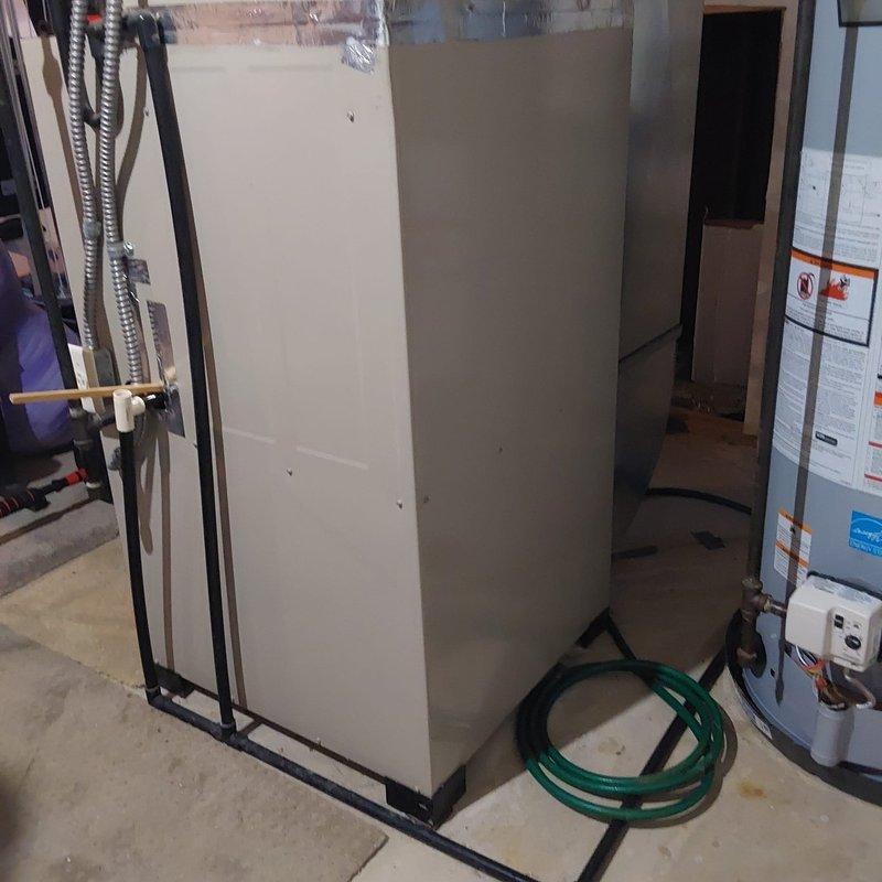 Completed full HVAC system retrofit including furnace and air conditioning replacement. Installed new outdoor condenser unit on existing concrete pad with proper refrigerant line routing through exterior wall, and replaced indoor air handler in basement mechanical room. All equipment properly positioned, connected, and tested for optimal operation.
